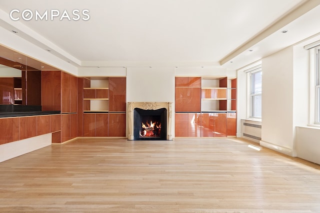 71 Park Ave Unit 12A, New York City, NY 10016 - unfurnished living room featuring light wood finished floors, a high end fireplace, and built in shelves
