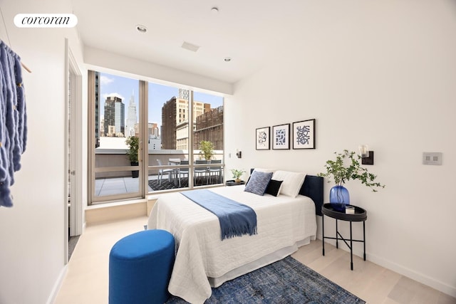 76 Madison Ave Unit Ph1, New York City, NY 10016 - bedroom featuring a view of skyline, wood finished floors, recessed lighting, and access to outside