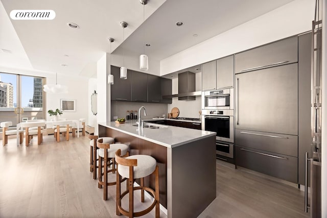 76 Madison Ave Unit Ph1, New York City, NY 10016 - kitchen with appliances with stainless steel finishes, light wood finished floors, a breakfast bar area, modern cabinets, and a peninsula