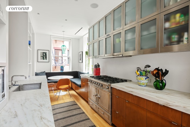 7 Harrison St Unit 4S, New York City, NY 10013 - kitchen with light wood-type flooring, light stone countertops, stainless steel appliances, and hanging light fixtures