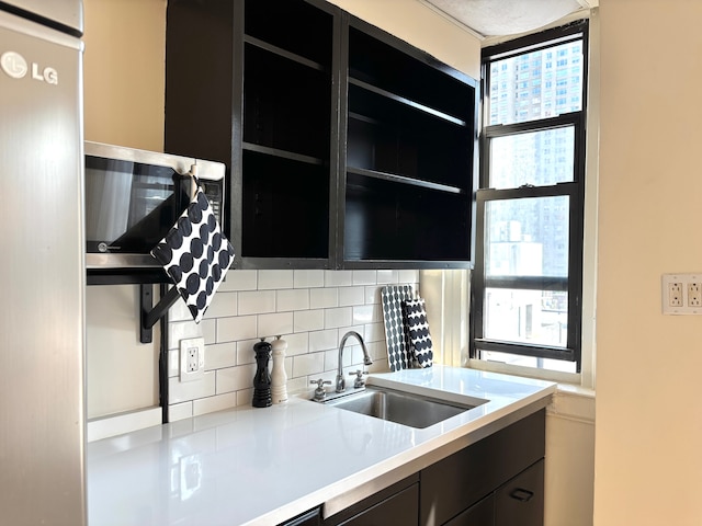 333 E 53rd St Unit 9-N, New York City, NY 10022 - kitchen featuring dark cabinetry, backsplash, and light countertops