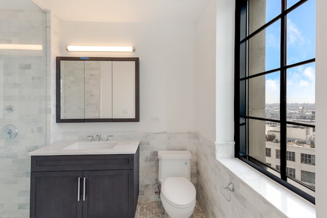 27-21 44th Dr Unit 1601, New York City, NY 11101 - bathroom featuring tile walls, vanity, a wainscoted wall, and a tile shower