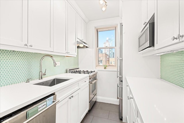 309 E 87th St Unit 7-J, New York City, NY 10128 - kitchen with appliances with stainless steel finishes, light tile patterned flooring, under cabinet range hood, tasteful backsplash, and light countertops
