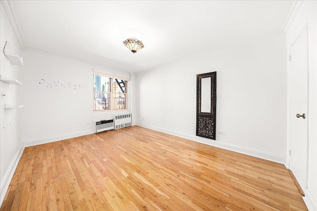 309 E 87th St Unit 7-J, New York City, NY 10128 - empty room featuring radiator heating unit, ornamental molding, and light wood-style flooring