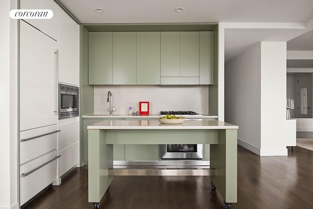 388 Bridge St Unit 35Ab, New York City, NY 11201 - kitchen with green cabinetry, stainless steel microwave, light countertops, dark wood finished floors, and recessed lighting