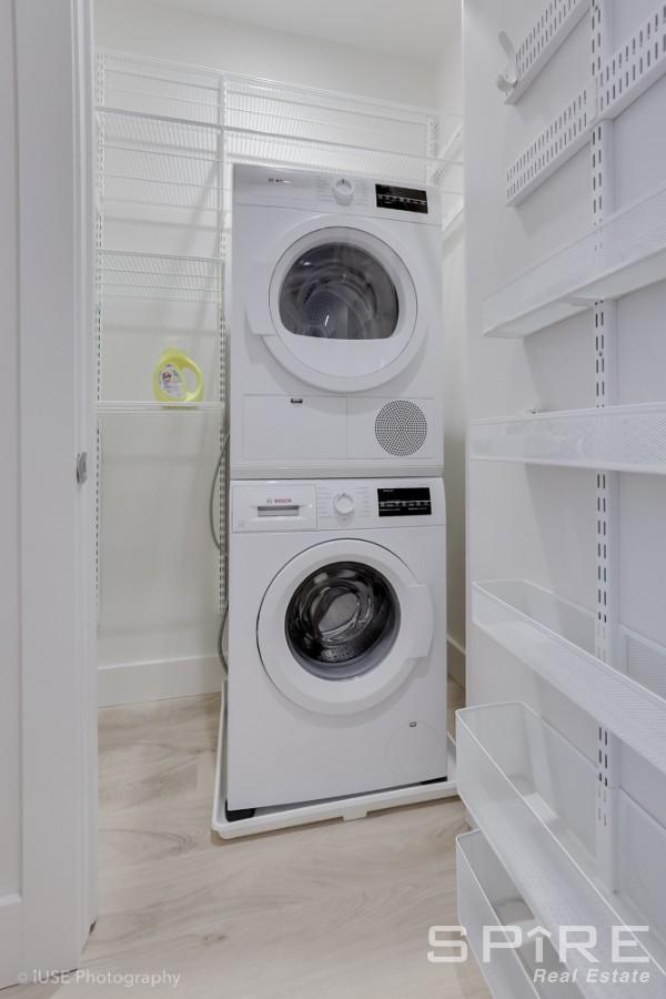 111 Montgomery St Unit 1N, New York City, NY 11225 - laundry area featuring stacked washer / drying machine and wood finished floors