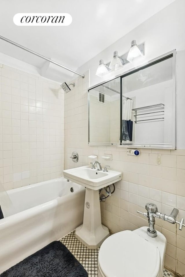 45 Tudor City Pl Unit 1002, New York City, NY 10017 - bathroom with tile walls, shower / tub combo with curtain, backsplash, and tile patterned flooring