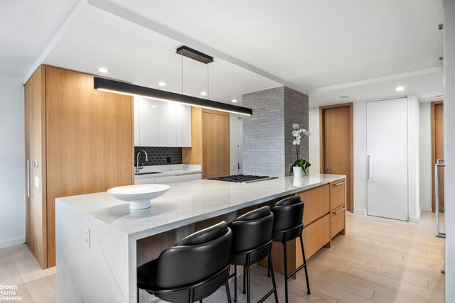 201 W 70th St Unit 24B, New York City, NY 10023 - kitchen with modern cabinets, tasteful backsplash, a breakfast bar, recessed lighting, and light stone counters
