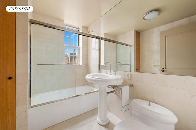 28 E 70th St Unit Ph1, New York City, NY 10021 - full bathroom featuring tile walls, bath / shower combo with glass door, and tile patterned floors