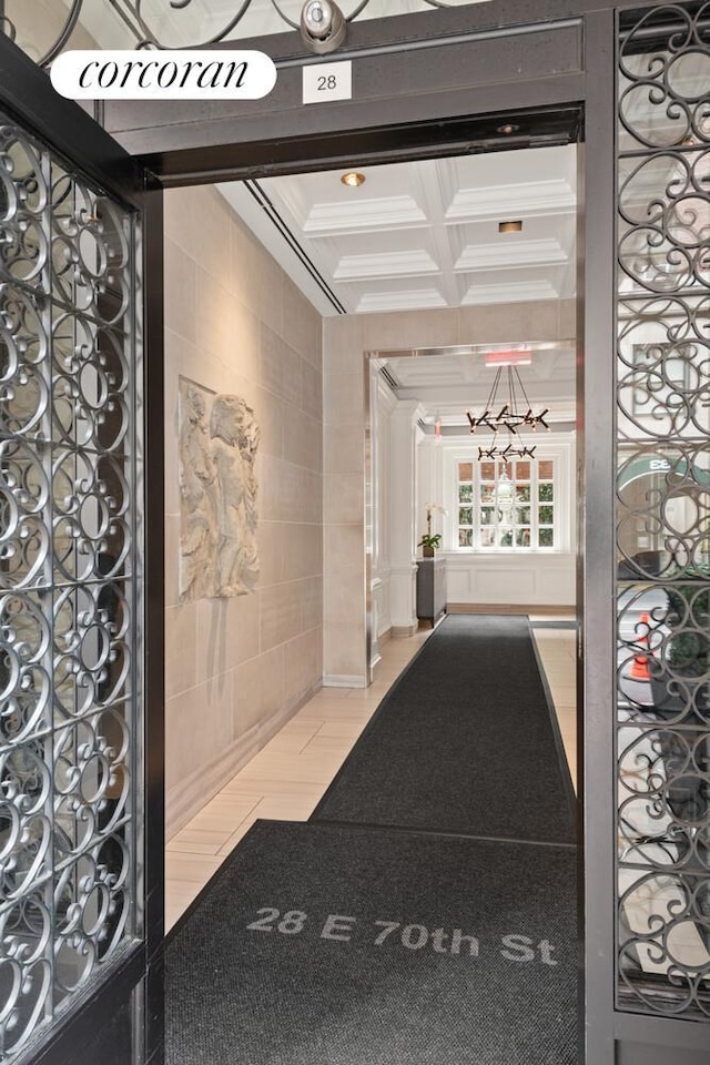 28 E 70th St Unit Ph1, New York City, NY 10021 - community lobby featuring tile walls, coffered ceiling, beamed ceiling, and ornamental molding