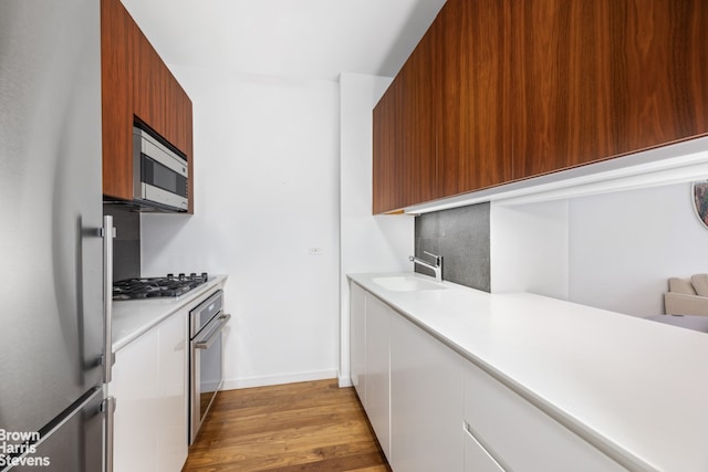 515 E 72nd St Unit 5F, New York City, NY 10021 - kitchen with stainless steel appliances, light countertops, light wood-type flooring, and modern cabinets