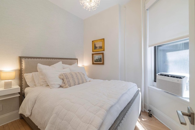 350 W 48th St Unit 4E, New York City, NY 10036 - bedroom with light wood-style floors and a chandelier
