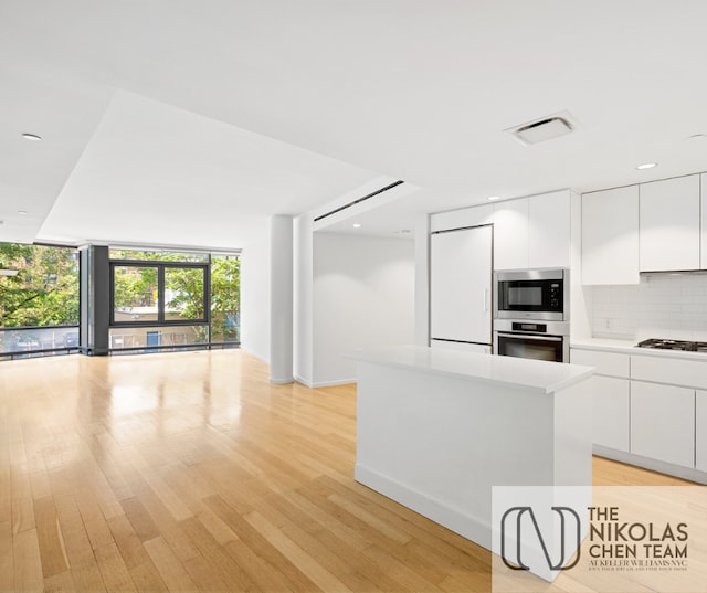 425 W 53rd St Unit 205, New York City, NY 10019 - kitchen with stainless steel appliances, modern cabinets, open floor plan, backsplash, and floor to ceiling windows