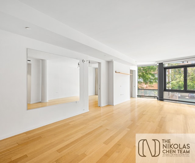 425 W 53rd St Unit 205, New York City, NY 10019 - unfurnished room with light wood-style floors, a wall of windows, and baseboard heating