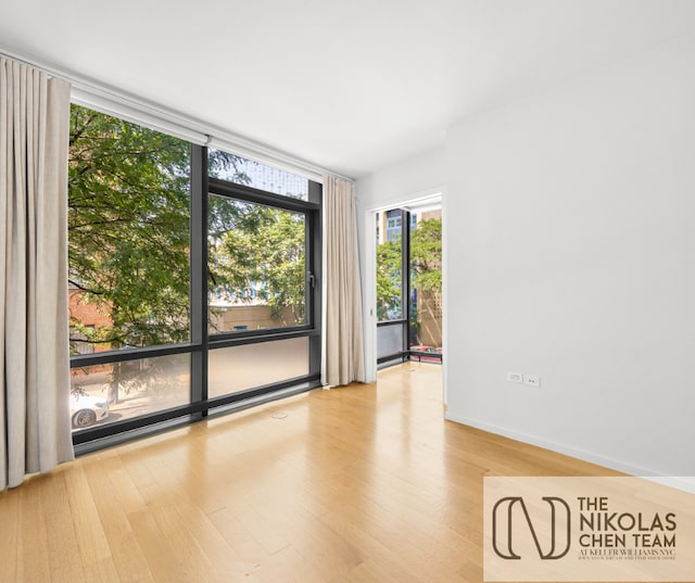 425 W 53rd St Unit 205, New York City, NY 10019 - unfurnished room with a wall of windows and light wood-style floors
