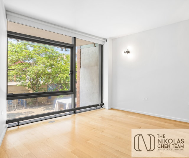 425 W 53rd St Unit 205, New York City, NY 10019 - unfurnished room featuring wood finished floors and expansive windows