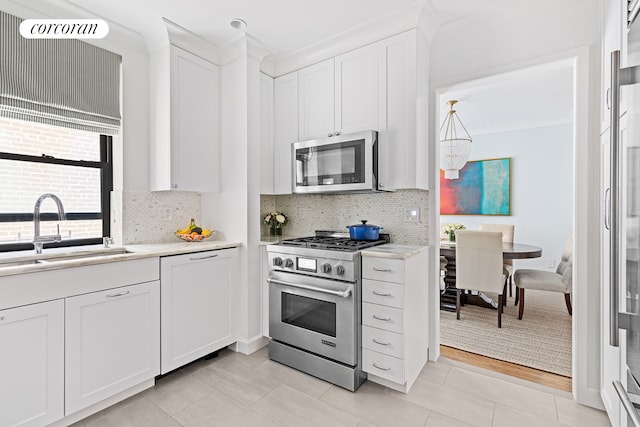 174 W 76th St Unit 3H, New York City, NY 10023 - kitchen with appliances with stainless steel finishes, light countertops, white cabinetry, tasteful backsplash, and light tile patterned flooring