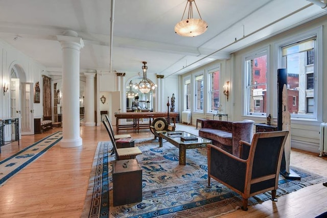 684 Broadway Unit 4E, New York City, NY 10012 - living room featuring decorative columns, wood finished floors, radiator, and a chandelier