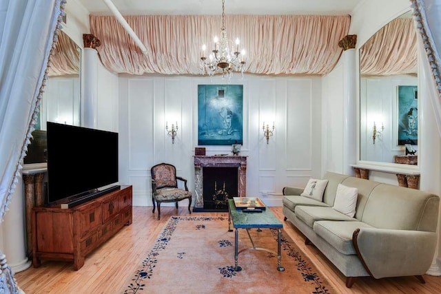 684 Broadway Unit 4E, New York City, NY 10012 - living area featuring a decorative wall, light wood-style floors, a fireplace, and a chandelier