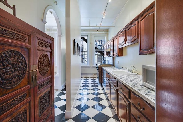 684 Broadway Unit 4E, New York City, NY 10012 - kitchen featuring light floors, track lighting, light countertops, and arched walkways
