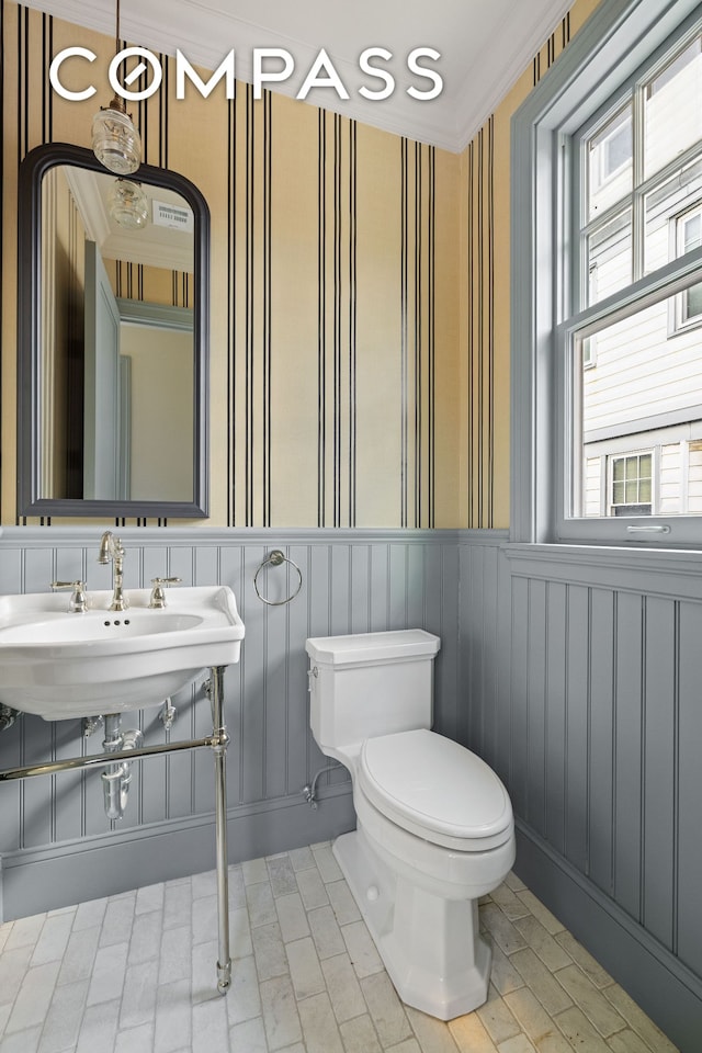320 E 18th St Unit 5, New York City, NY 11226 - half bath featuring plenty of natural light, wainscoting, crown molding, and wallpapered walls
