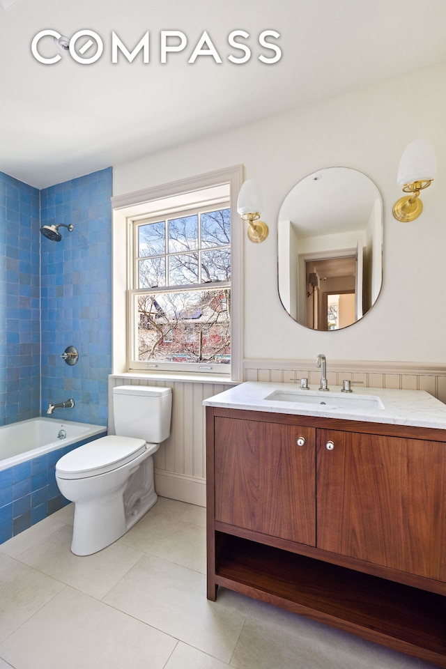 320 E 18th St Unit 5, New York City, NY 11226 - full bathroom featuring vanity, tile patterned floors, tiled shower / bath, and a wainscoted wall