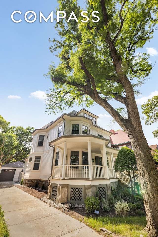 320 E 18th St Unit 5, New York City, NY 11226 - view of front of house featuring covered porch, an outbuilding, and driveway