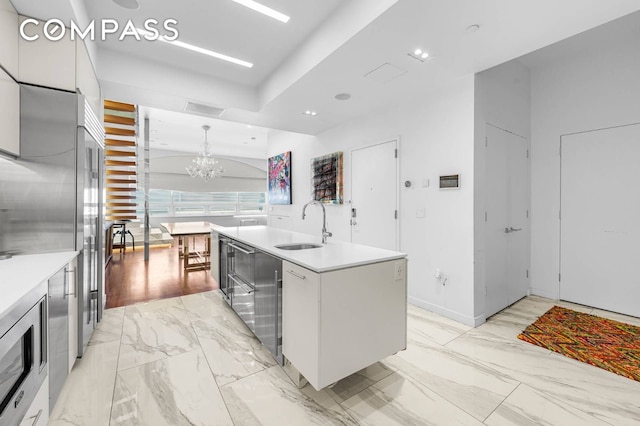 124 E 13th St Unit 3, New York City, NY 10003 - kitchen with a chandelier, a kitchen island with sink, light countertops, modern cabinets, and recessed lighting