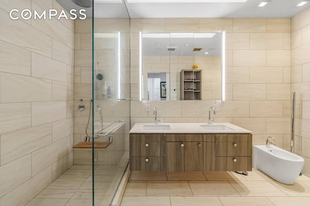 124 E 13th St Unit 3, New York City, NY 10003 - bathroom with tile walls, a shower stall, double vanity, and tile patterned flooring