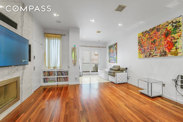 124 E 13th St Unit 3, New York City, NY 10003 - unfurnished living room with a large fireplace, wood finished floors, and recessed lighting