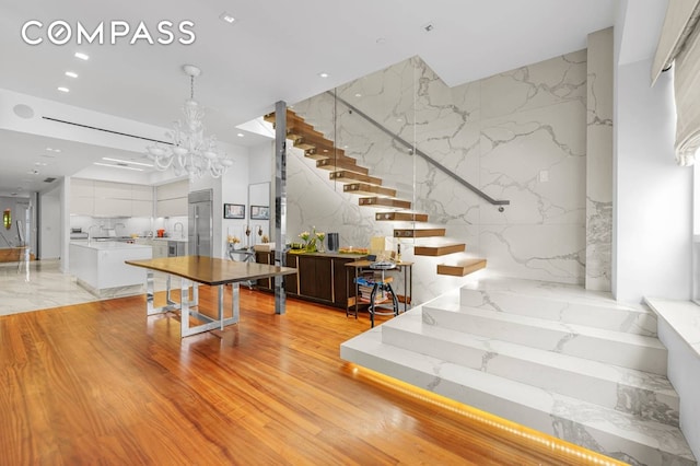 124 E 13th St Unit 3, New York City, NY 10003 - stairway with stone wall, recessed lighting, and a chandelier
