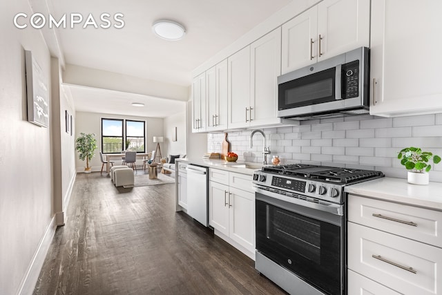 160 Ocean Pkwy Unit 6C, New York City, NY 11218 - kitchen featuring appliances with stainless steel finishes, dark wood-style flooring, decorative backsplash, light countertops, and white cabinetry
