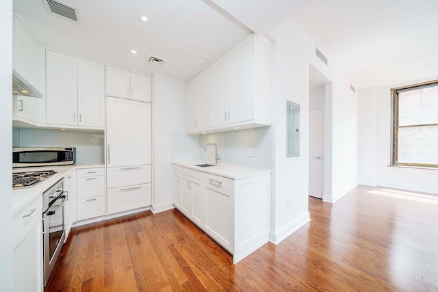 1182 Broadway Unit 10D, New York City, NY 10001 - kitchen with stainless steel appliances, tasteful backsplash, light countertops, light wood-style flooring, and recessed lighting