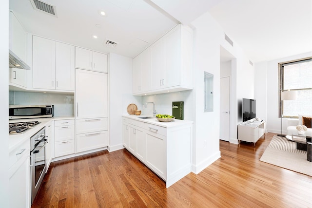 1182 Broadway Unit 10D, New York City, NY 10001 - kitchen featuring appliances with stainless steel finishes, light countertops, light wood finished floors, and recessed lighting