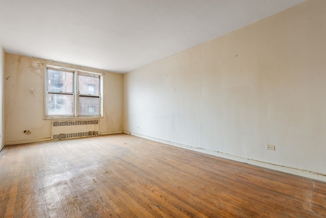 67-30 Clyde St Unit 5R, New York City, NY 11375 - spare room with radiator heating unit and wood finished floors