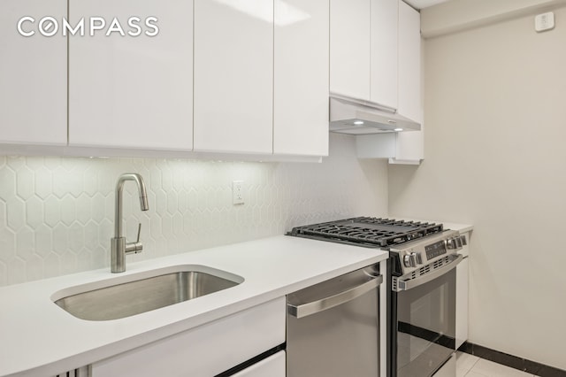 211 E 53rd St Unit 7C, New York City, NY 10022 - kitchen featuring appliances with stainless steel finishes, under cabinet range hood, white cabinetry, decorative backsplash, and modern cabinets