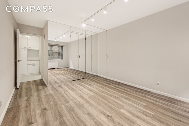 211 E 53rd St Unit 7C, New York City, NY 10022 - unfurnished room with light wood-type flooring and rail lighting