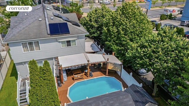 2054 Richmond Ave, New York City, NY 10314 - rear view of property with a wooden deck, a fenced backyard, roof mounted solar panels, and roof with shingles