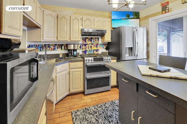 2054 Richmond Ave, New York City, NY 10314 - kitchen featuring appliances with stainless steel finishes, under cabinet range hood, a chandelier, and dark countertops