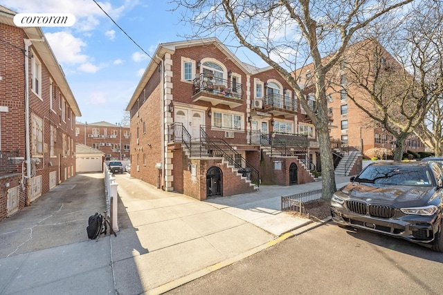 57 Bay 31st St Unit 3A, New York City, NY 11214 - view of front of home featuring brick siding, stairs, a balcony, and an outbuilding