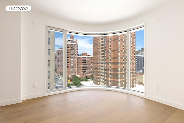250 E 25th St Unit 9D, New York City, NY 10010 - spare room with a view of city, wood finished floors, and plenty of natural light
