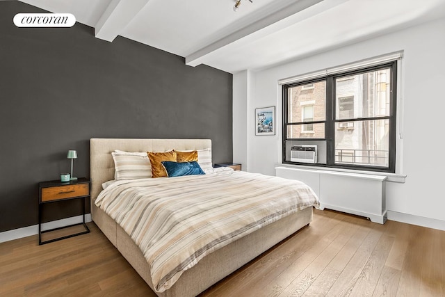 215 W 78th St Unit 2C, New York City, NY 10024 - bedroom with beam ceiling, wood finished floors, and radiator