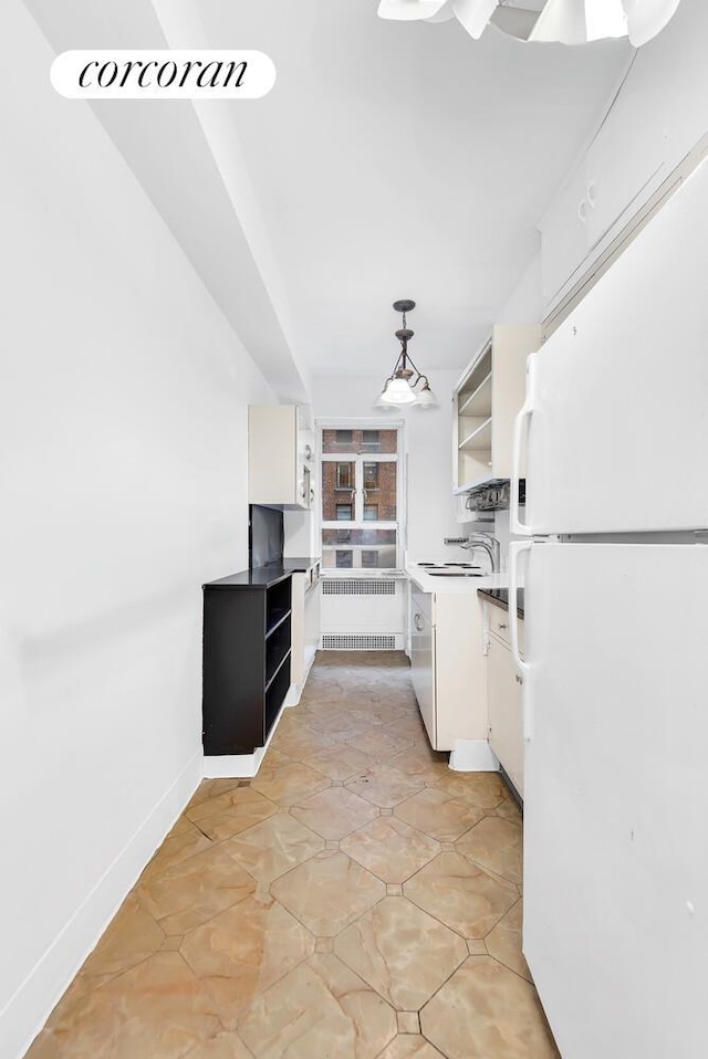 19 E 88th St Unit 4H, New York City, NY 10128 - kitchen featuring freestanding refrigerator, radiator, open shelves, white cabinets, and decorative light fixtures