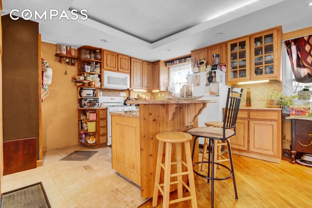 88-29 212th St, New York City, NY 11427 - kitchen with white appliances, open shelves, a kitchen breakfast bar, tasteful backsplash, and recessed lighting