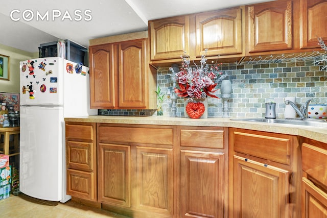 88-29 212th St, New York City, NY 11427 - kitchen with freestanding refrigerator, light countertops, brown cabinetry, and tasteful backsplash