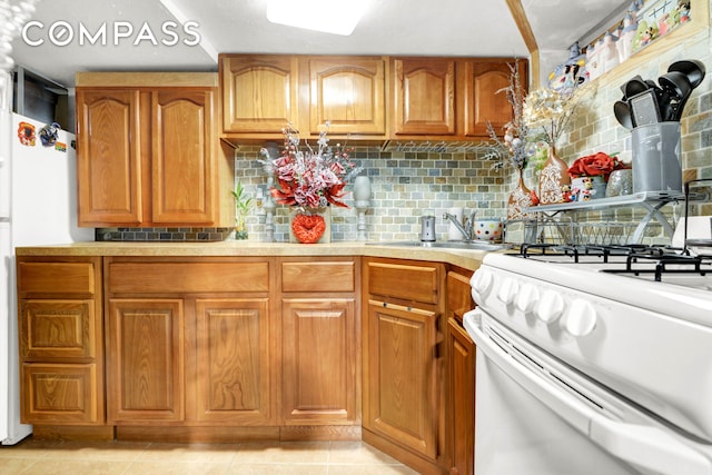 88-29 212th St, New York City, NY 11427 - kitchen featuring white range with gas stovetop, brown cabinets, light countertops, tasteful backsplash, and light tile patterned floors