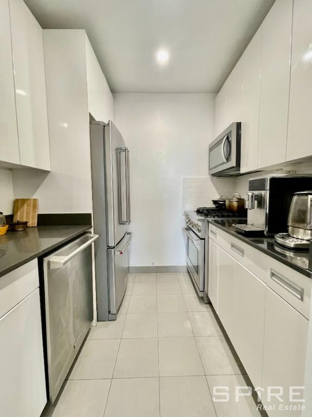 99 John St Unit 2201, New York City, NY 10038 - kitchen with appliances with stainless steel finishes, dark countertops, and white cabinetry