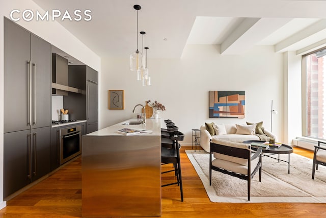 76 Madison Ave Unit 8C, New York City, NY 10016 - kitchen featuring stainless steel oven, a kitchen breakfast bar, light wood-type flooring, and modern cabinets
