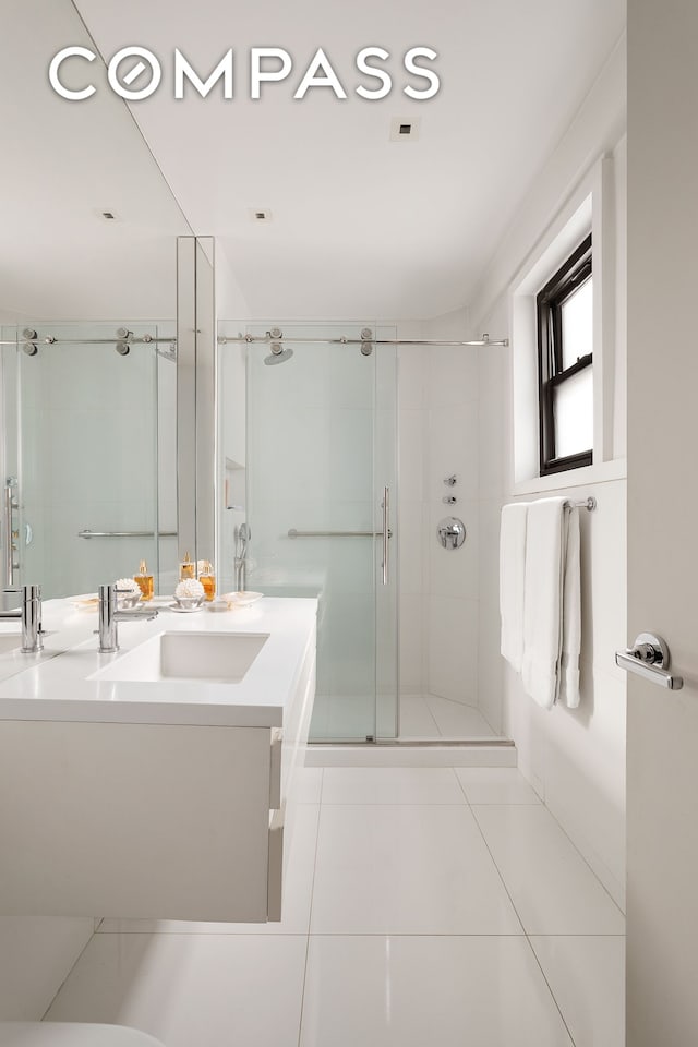 58 W 58th St Unit 19A, New York City, NY 10019 - full bathroom featuring vanity, a shower stall, and tile patterned floors