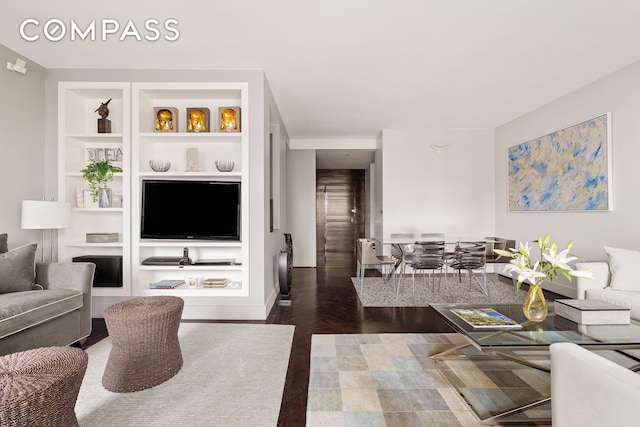 58 W 58th St Unit 19A, New York City, NY 10019 - living room with built in features and dark wood-type flooring